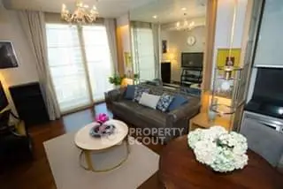 Luxurious living room with elegant decor and natural light, featuring a cozy sofa and stylish chandelier.