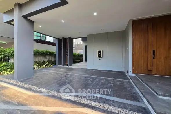 Modern building entrance with sleek design and lush greenery