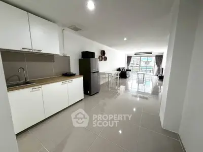 Spacious modern kitchen and living area with sleek design and ample natural light.