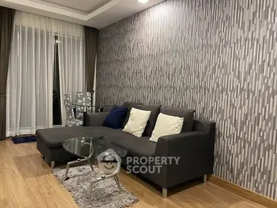 Modern living room with stylish gray sofa and glass coffee table