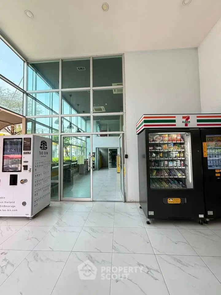 Modern building entrance with vending machines and glass facade