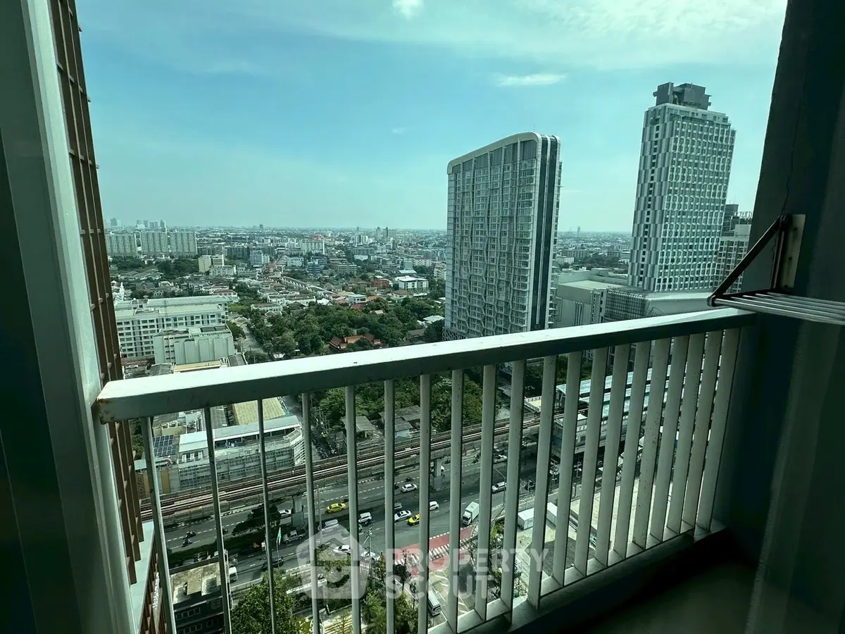 Stunning cityscape view from a high-rise balcony overlooking urban skyline and modern architecture.