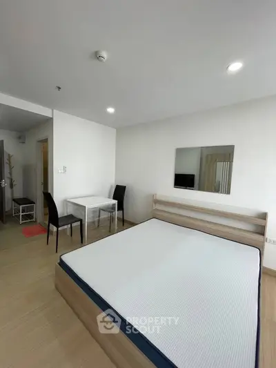 Modern bedroom with minimalist design and natural light, featuring a comfortable bed and sleek furniture.