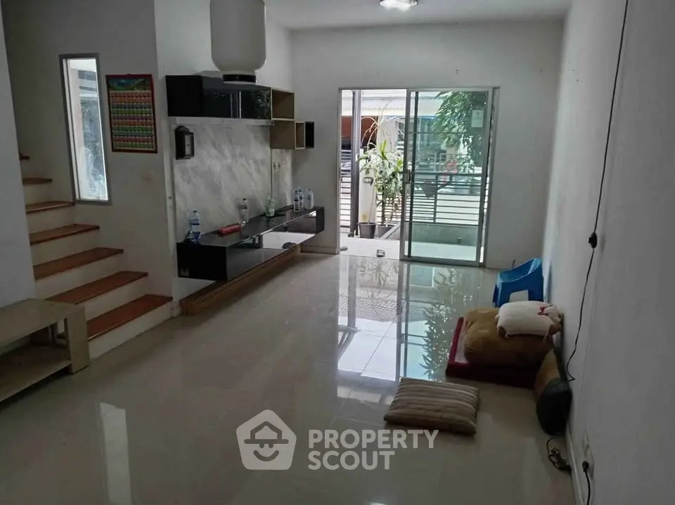 Spacious living room with modern decor and large windows leading to a balcony.