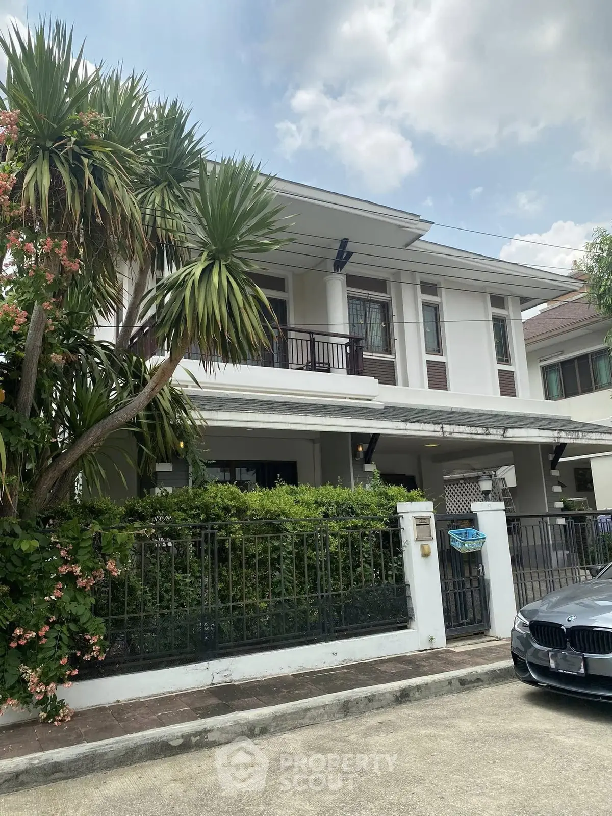 Charming two-story house with lush greenery and modern facade in a serene neighborhood.