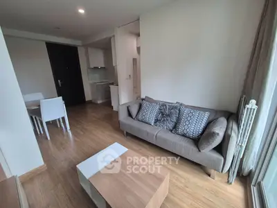 Modern living room with stylish decor and wooden flooring, open layout leading to dining area.