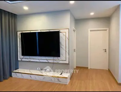 Modern living room with sleek TV setup and elegant wooden flooring.