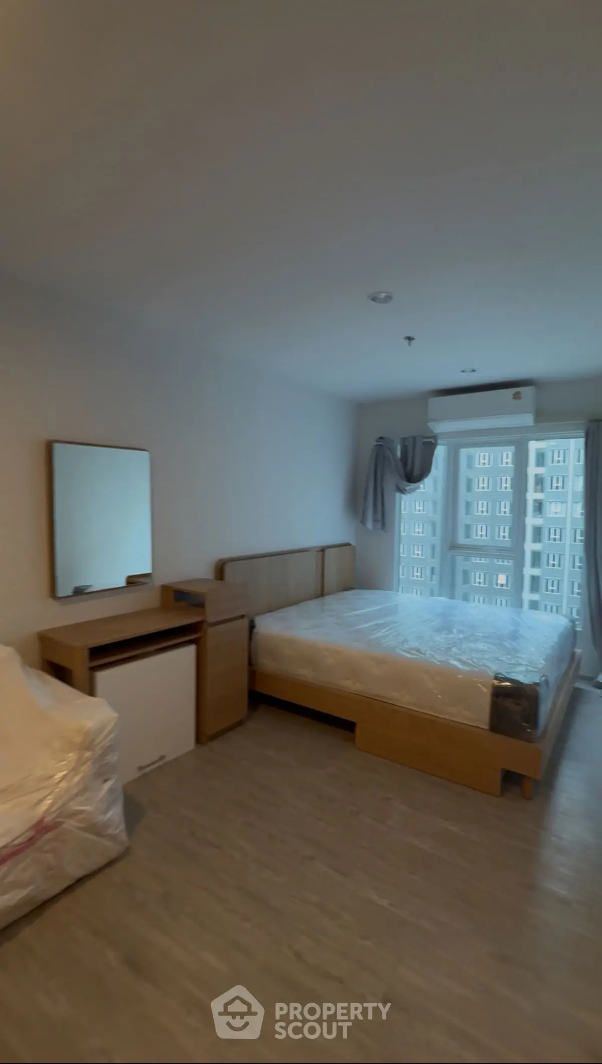 Spacious bedroom with modern furnishings and large window view