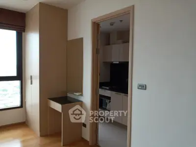 Modern apartment interior with wooden flooring and sleek kitchen design.