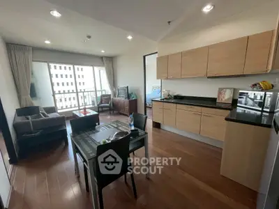 Modern open-plan living room and kitchen with wooden flooring and balcony view.