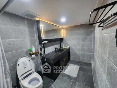 Modern bathroom with sleek design, featuring a large mirror, elegant vanity, and contemporary fixtures.