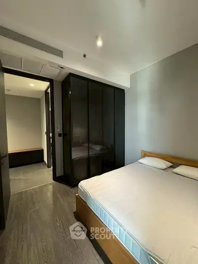 Modern bedroom with sleek design and ample natural light, featuring a comfortable bed and stylish wardrobe.