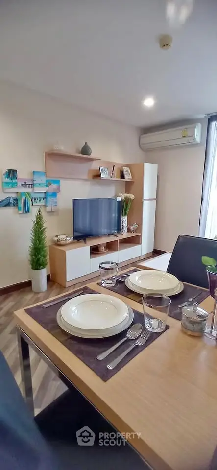 Modern living room with stylish decor and dining area, featuring sleek furniture and contemporary design.