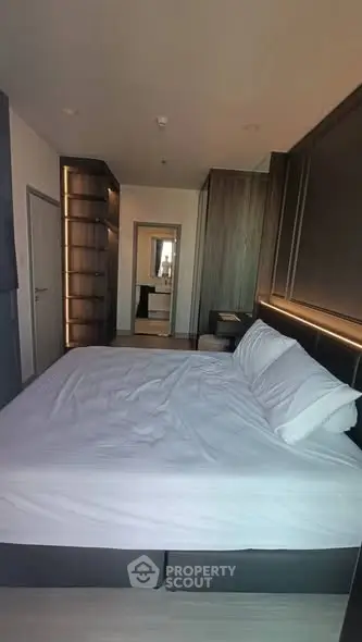 Luxurious bedroom with modern design and ambient lighting, featuring a spacious bed and sleek furnishings.