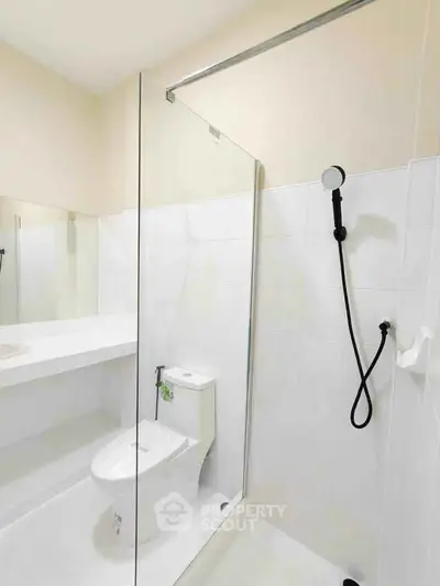 Modern bathroom with glass shower and sleek fixtures in a contemporary apartment.