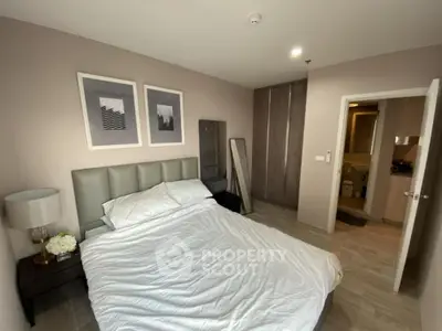 Modern bedroom with stylish decor and ensuite bathroom in a contemporary apartment.