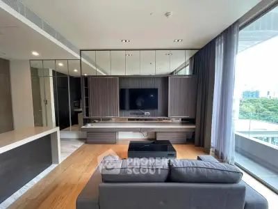 Modern living room with large windows and sleek furniture in a high-rise apartment.
