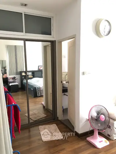 Cozy bedroom with mirrored wardrobe and wooden flooring in modern apartment