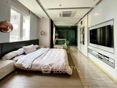 Luxurious modern bedroom with sleek design and large TV, featuring stylish lighting and spacious layout.