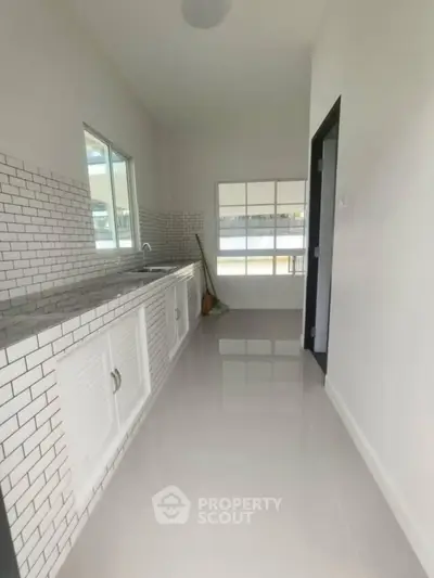 Modern kitchen with sleek white cabinetry and subway tile backsplash