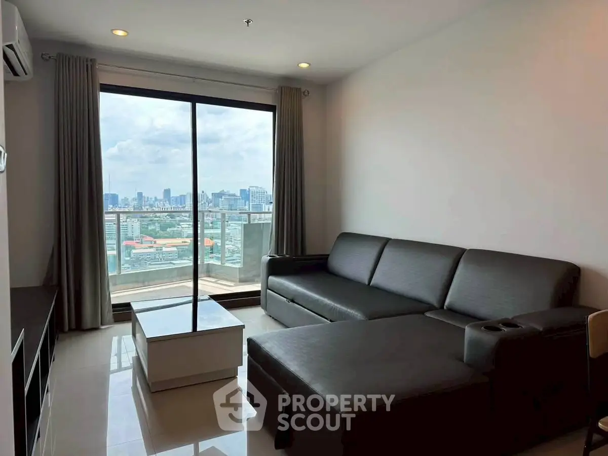Modern living room with city view and sleek furniture in high-rise apartment.