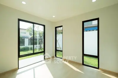 Bright and airy room with large windows and garden view, perfect for modern living.