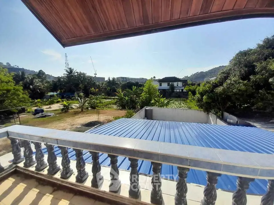 Stunning balcony view overlooking lush greenery and distant hills, perfect for nature lovers.