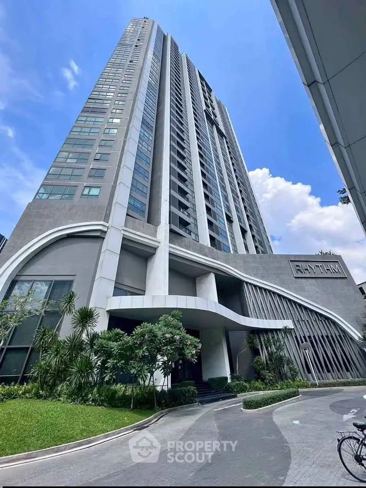 Stunning modern high-rise building with sleek architectural design and lush landscaping.