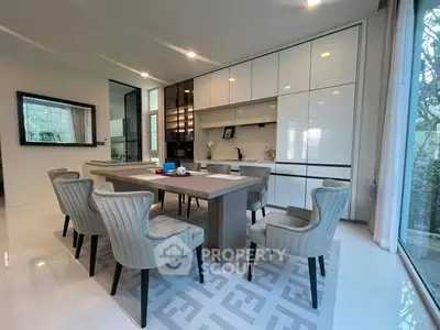 Modern kitchen with sleek cabinetry and elegant dining area in luxury home.