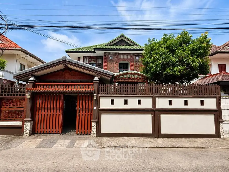 Charming traditional-style house with gated entrance and lush greenery, perfect for family living.