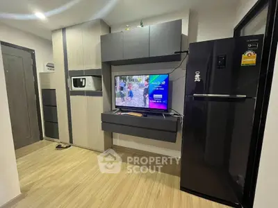 Modern living room with sleek storage and large refrigerator, perfect for urban living.