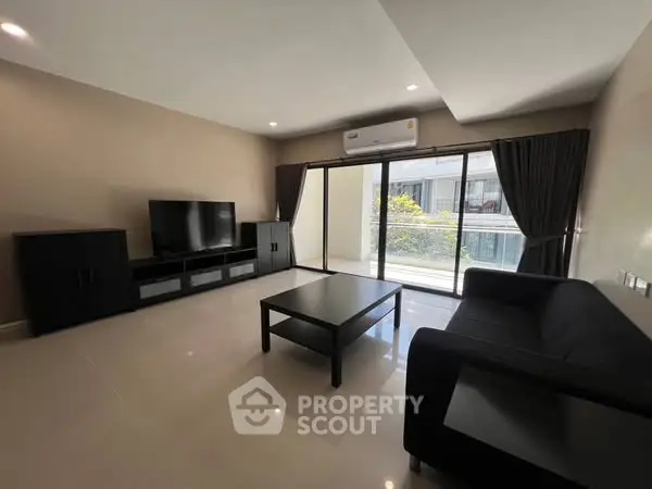 Spacious modern living room with sleek furniture and large windows for natural light.