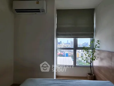 Modern bedroom with city view, featuring air conditioning and minimalist decor, perfect for urban living.
