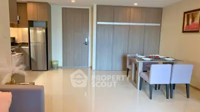 Modern open-plan living area with sleek kitchen and dining space, featuring elegant decor and ample natural light.