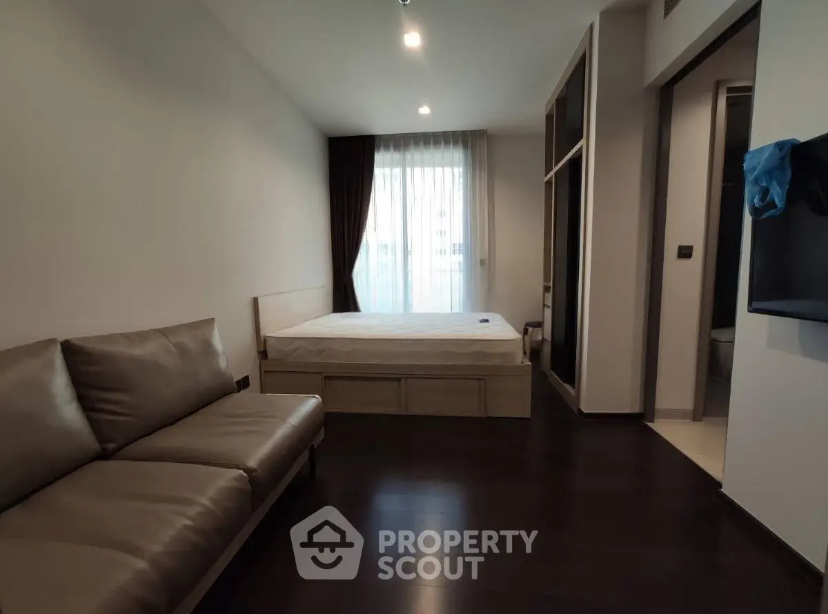 Modern bedroom with sleek design, featuring a comfortable bed and stylish sofa, perfect for urban living.