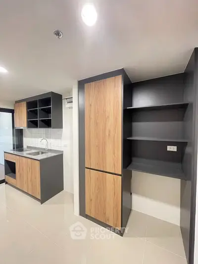 Modern kitchen with sleek cabinetry and open shelving in a contemporary apartment.