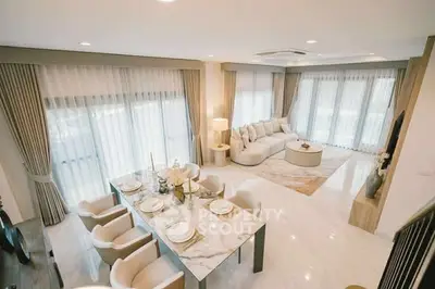 Luxurious open-plan living and dining area with elegant decor and ample natural light.