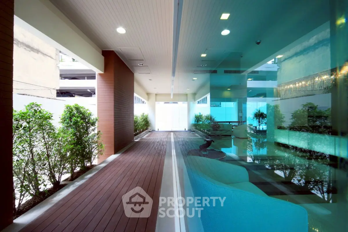 Modern building entrance with sleek design and lush greenery