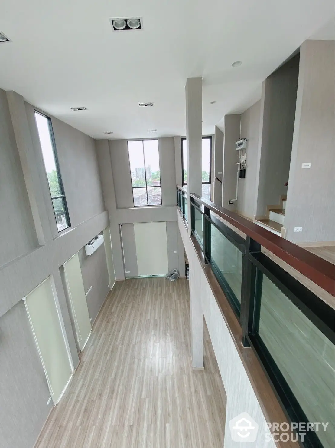 Spacious and modern open-layout interior with abundant natural light, featuring sleek finishes and a balcony with glass railing, perfect for urban living.