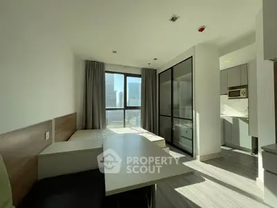 Modern studio apartment with large windows and sleek design in urban setting.