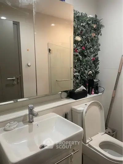 Modern bathroom with sleek fixtures and floral wall decor