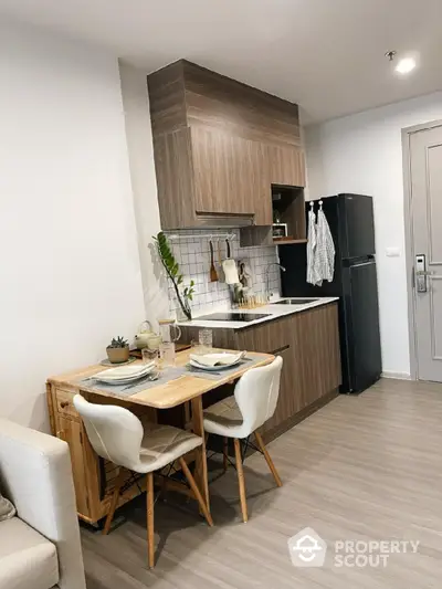 Modern kitchen with wooden cabinets and dining area in cozy apartment