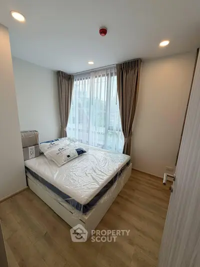 Cozy bedroom with large window and modern decor in a stylish apartment.