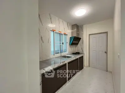 Modern kitchen with sleek marble countertops and gas stove in a stylish apartment.