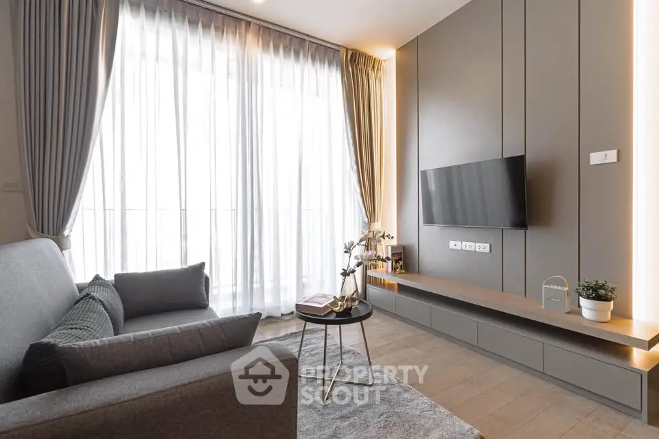 Modern living room with sleek design, large window, and stylish furniture in a contemporary apartment.