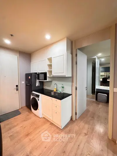 Modern apartment interior with compact kitchen and washing machine