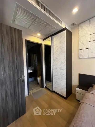 Modern bedroom with ensuite bathroom and stylish wooden flooring