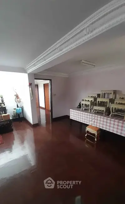 Spacious living area with polished wooden floors and decorative elements.