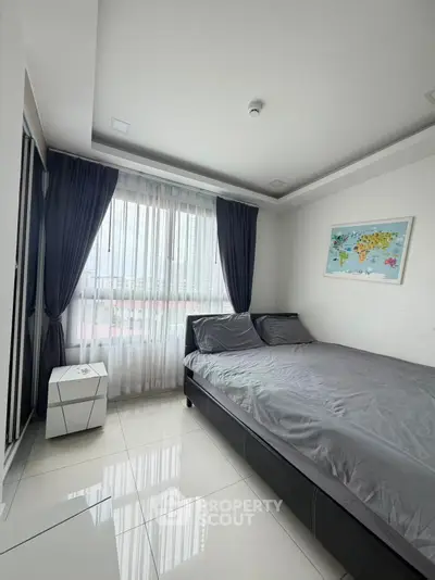 Modern bedroom with sleek design and large window offering natural light.