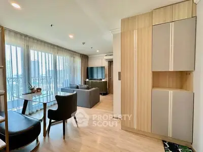 Modern living room with stylish furniture and large windows offering city views.